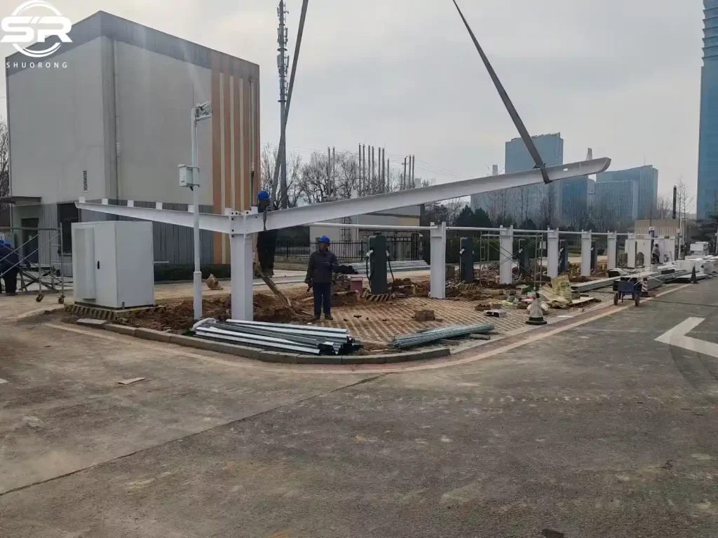 SR Solar professional installers mounting cantilever beams on a single-post double-sided solar carport structure at a project site.