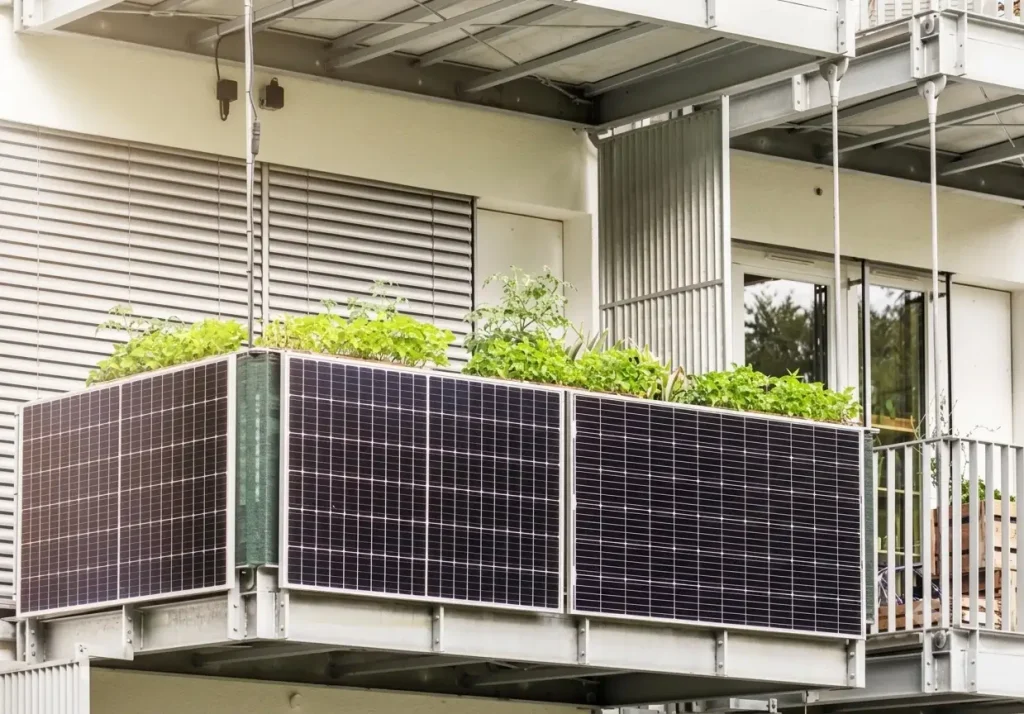 A apartment balcony with solar panels mounted on the railing, using SR Solar balcony PV mounting systems, overlooking other balconies.
