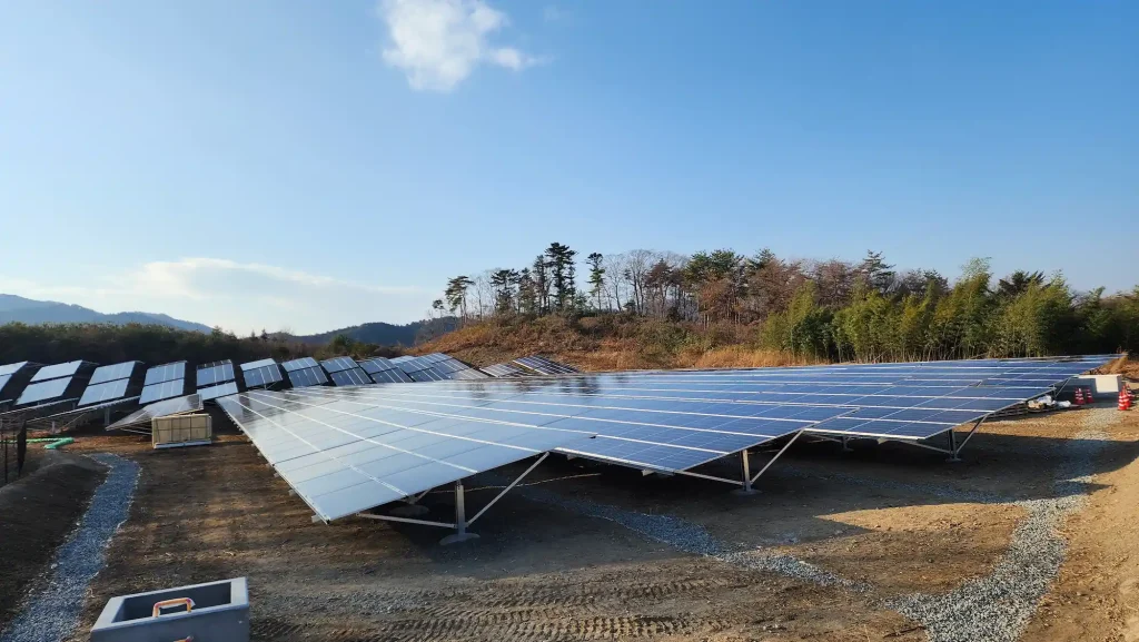 SR Solar aluminum and steel ground solar racking system anchored on concrete foundations in a hillside solar farm installation.