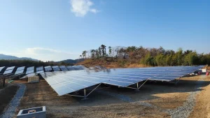 SR Solar aluminum and steel ground solar racking system anchored on concrete foundations in a hillside solar farm installation.