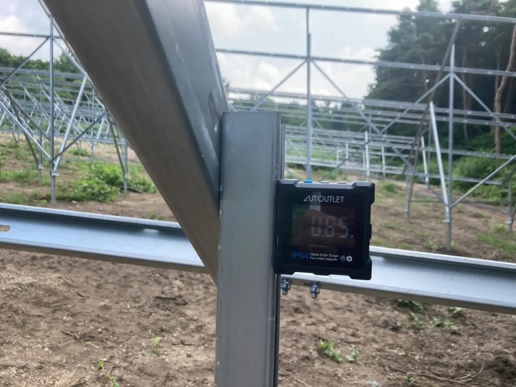 SR Solar ground mounting structure being measured with a digital level tool at the PNF Hokkaido project site in Japan.