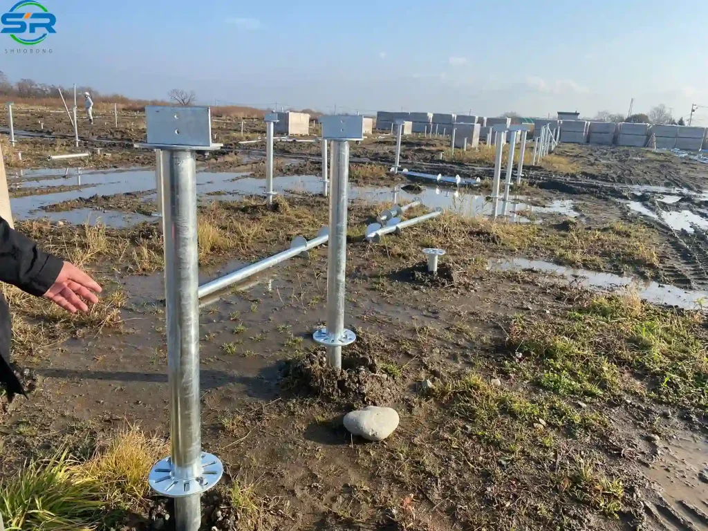 SR Solar hot-dip galvanized ground screw foundation for solar mounting systems on a muddy construction site, manufactured by premium OEM/ODM solar factory