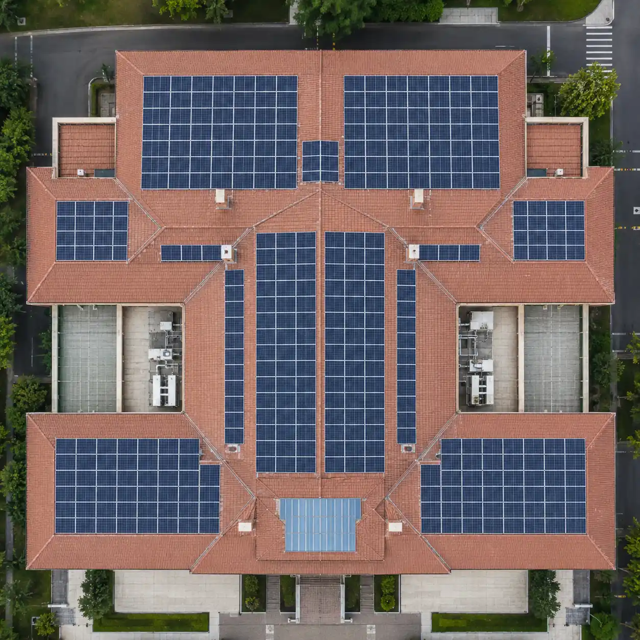Aerial view of a commercial building featuring a tile roof solar mounting system manufactured by SR Solar, showcasing engineering precision for global EPC contractors