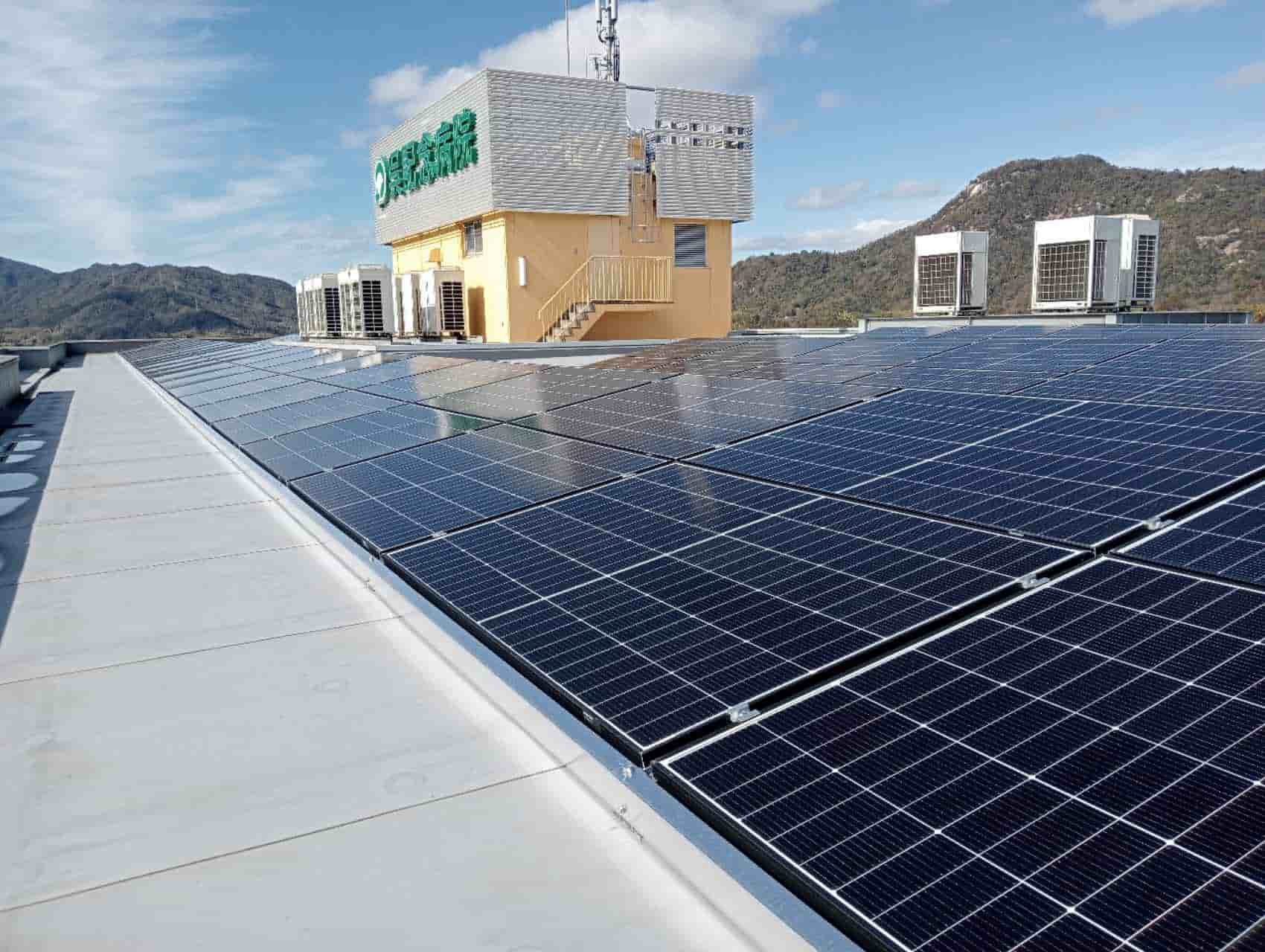 Precision-aligned solar panels mounted on SR Solar flat concrete roof tripod tracking profiles next to commercial HVAC facilities