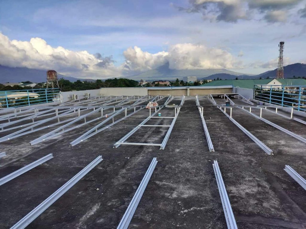 Extensive rows of empty aluminum solar triangle framing profiles and rails engineered by SR Solar on a flat concrete roof.