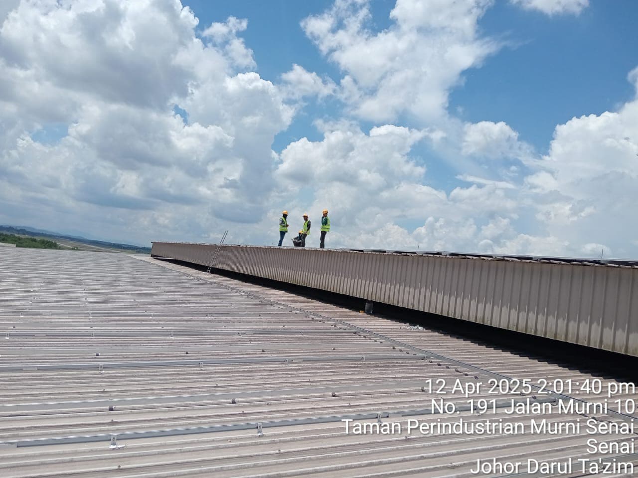 Engineers surveying a large industrial corrugated metal rooftop installation using the SR Solar L-feet mounting system in Malaysia.