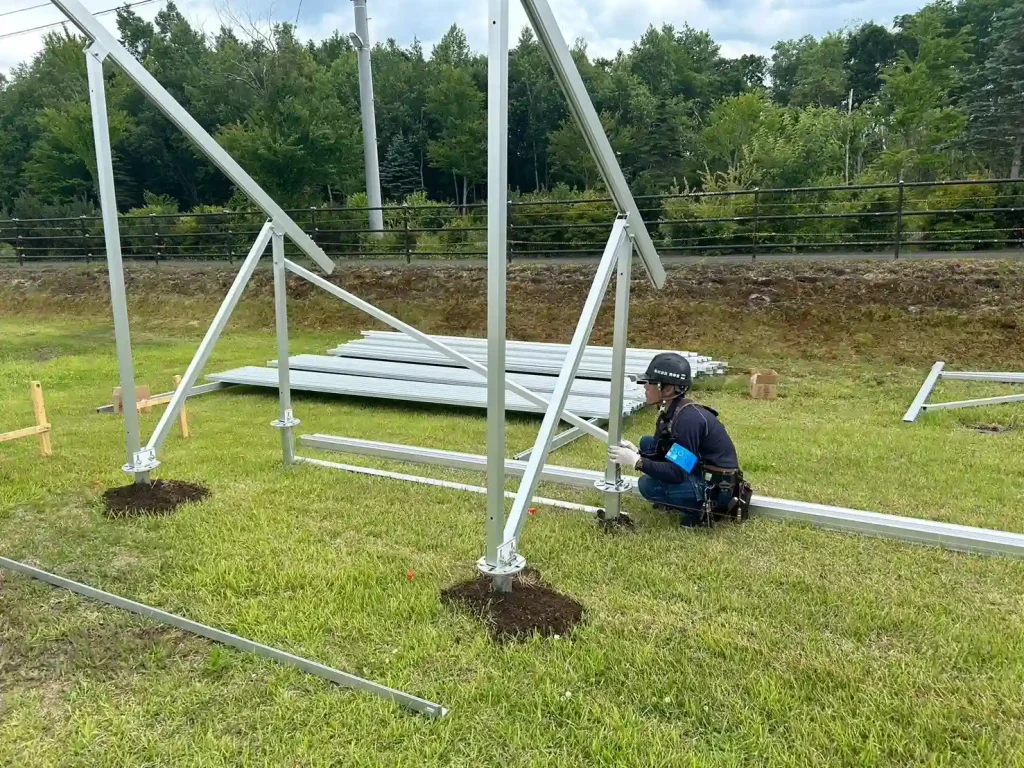 Field technician securing robust solar racking brackets engineered factory-direct by manufacturer SR Solar.