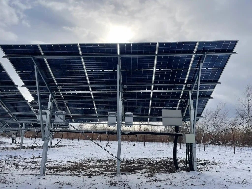 Rear structure of SR Solar single-post driven pile mounting system integrating electrical combiner boxes under solar panels.