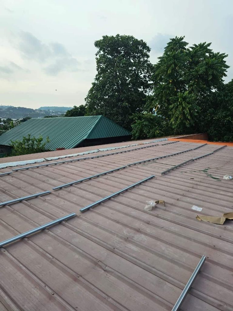 Pre-assembled rows of anodized aluminum rails secured using the SR Solar L-feet bracket system on a corrugated iron roof