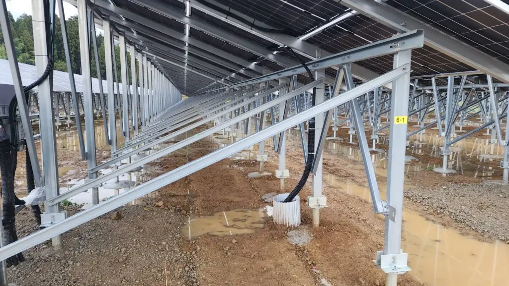 Side-angle close-up profile of a long row of concrete reinforced foundation pillars supporting SR Solar ZAM steel racking structures.