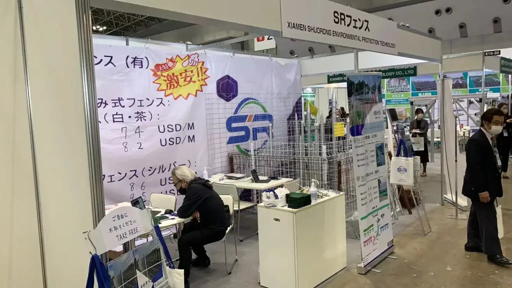 Visitors and staff at the SR Solar exhibition booth discussing ground screw solar foundations and mounting structures at PV EXPO.