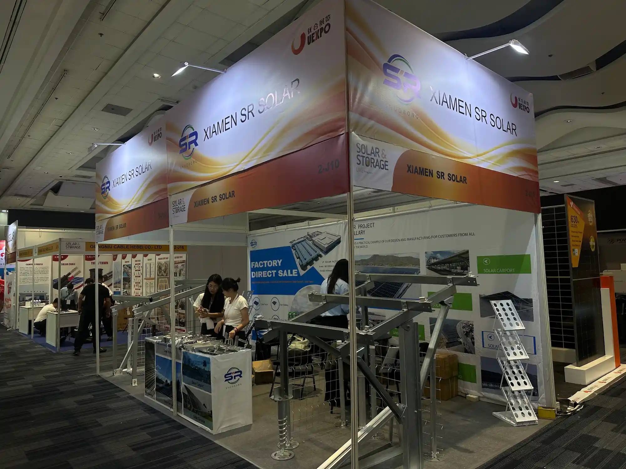 Visitors at the SR Solar exhibition stand evaluating heavy-duty solar mounting brackets and racking samples.